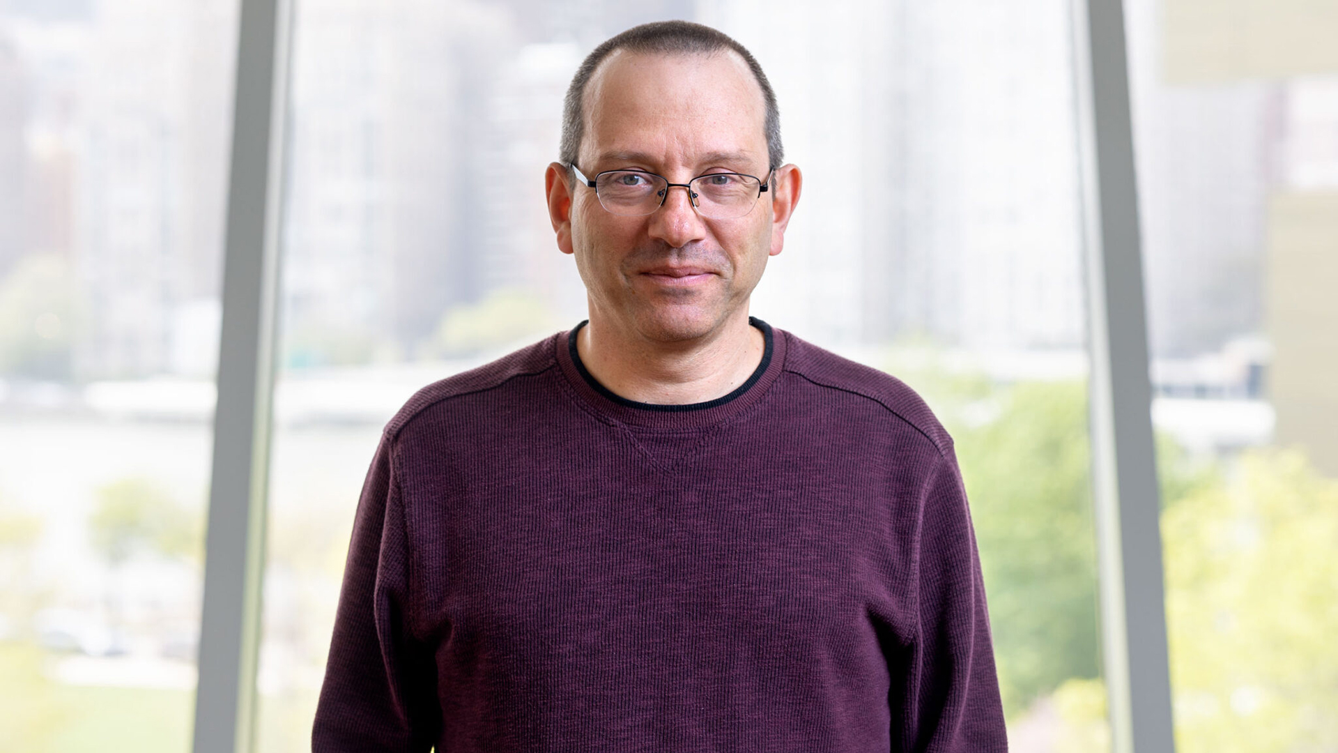 A color photo of a man with glasses.