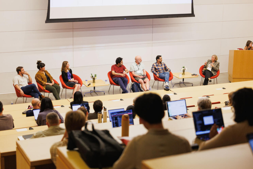 People listening to a panel in a auditorium