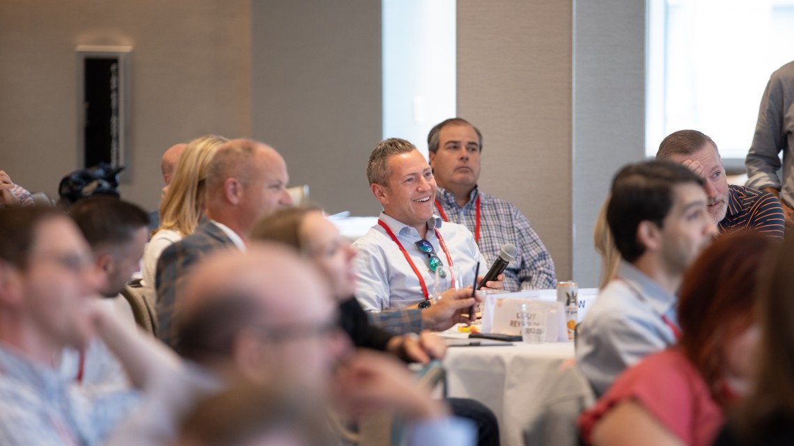 A color photo showing people sitting in a conference room