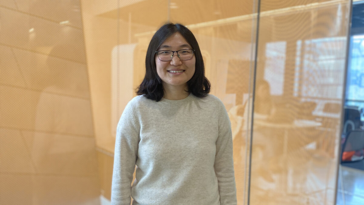 A color photo of a woman smiling for a photo