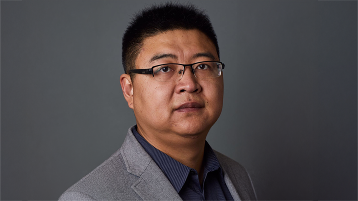 A color photo of a man with a gray background