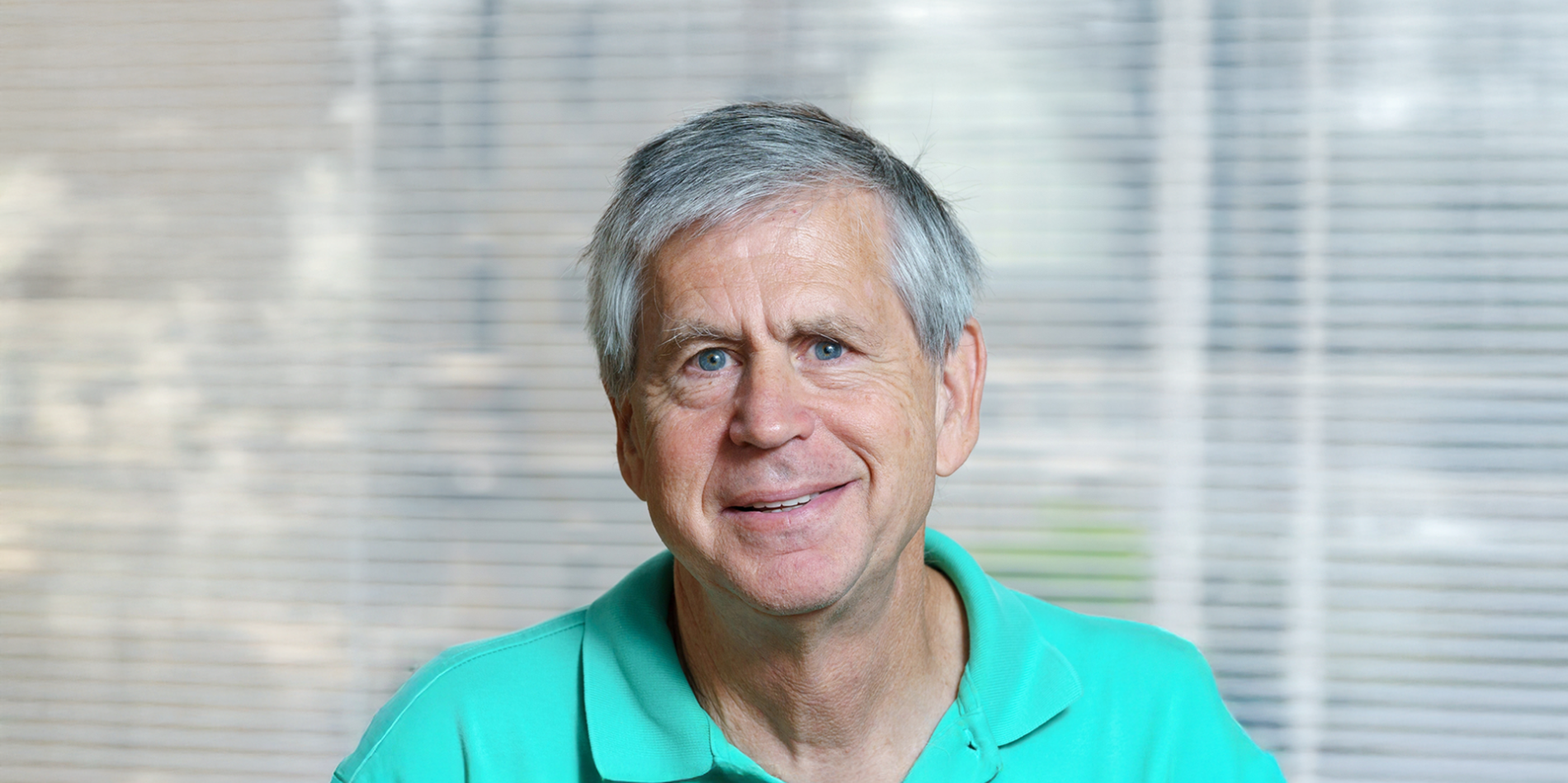 Portrait of Michael Macy in a teal shirt.